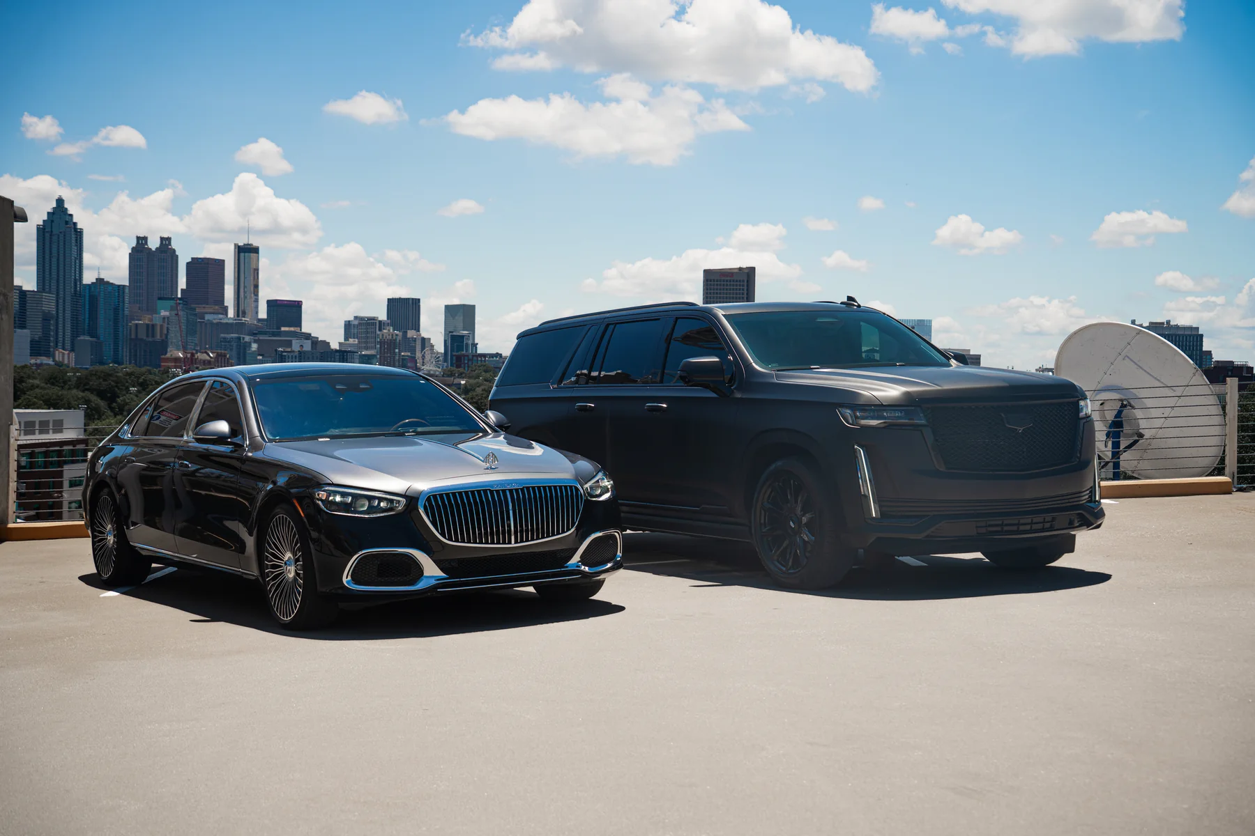 Cadillac Escalade and Mercedes-Maybach S580 with the Atlanta skyline