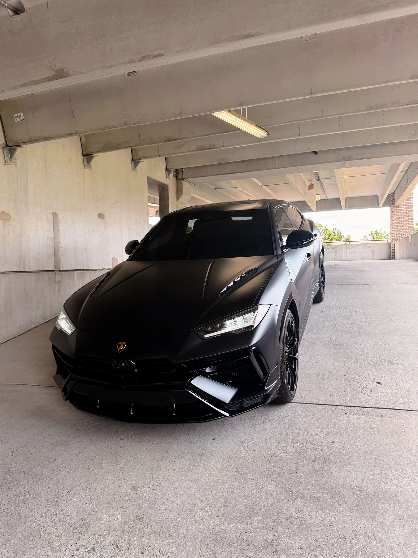 Matte black Lamborghini Urus S in a parking structure